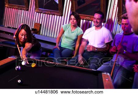 Stock Photograph - Young adults at a nightclub playing pool. Fotosearch