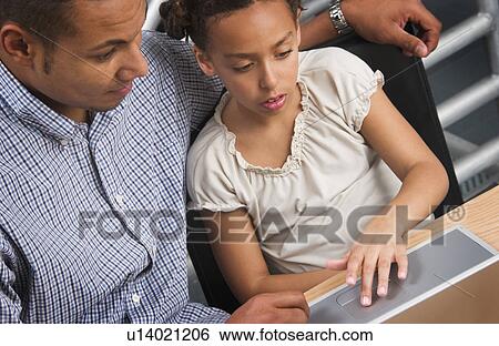 Stock Photograph - African American father helping daughter with homework. Fotosearch