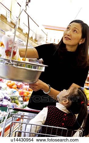 Picture - Asian mom and daughter shopping for groceries . Fotosearch