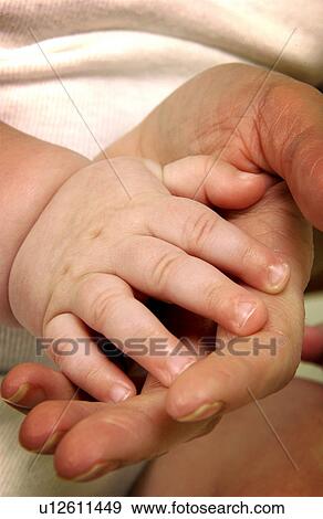 Stock Photo - Baby hand on adult hand. Fotosearch