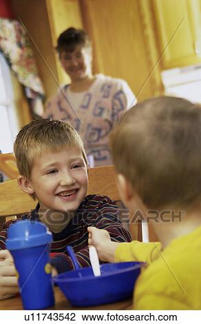 Stock Image - Boys eating breakfast. Fotosearch