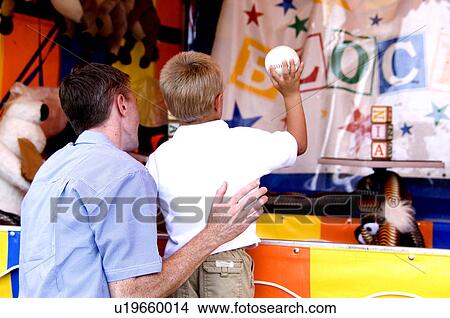 Father and son playing carnival game View Large Photo Image Picture - Father and son playing carnival game. Fotosearch
