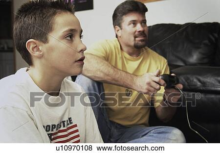 Stock Photo - Father and son playing video games. Fotosearch