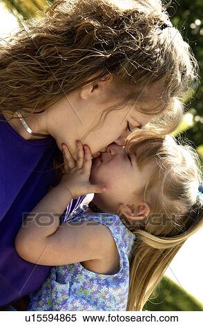 Stock Photography - Mother and daughter sharing a kiss. Fotosearch