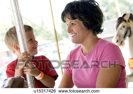 Stock Photograph - Mother and son on merry go round. Fotosearch
