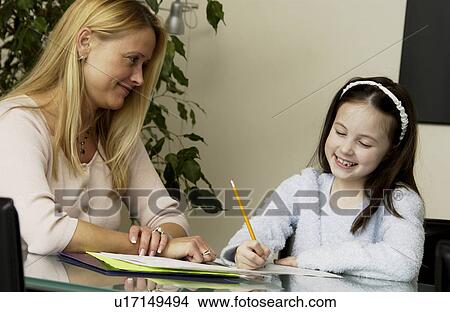 Mother helping daughter with homework View Large Photo Image Picture - Mother helping daughter with homework. Fotosearch