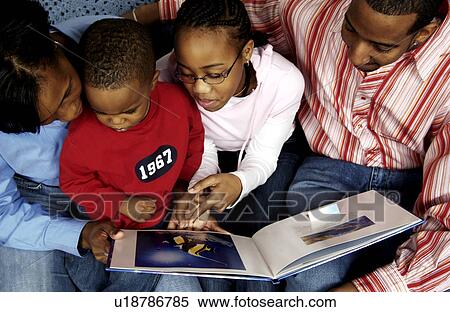 Stock Photography - Parents reading a book with kids. Fotosearch