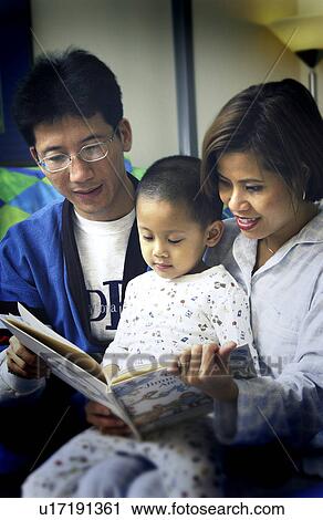 Stock Image - Parents reading to son. Fotosearch