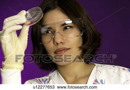 Stock Image - Lab technician examining slide. Fotosearch