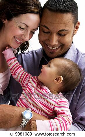 Stock Photo - Mother and Father holding daughter. Fotosearch