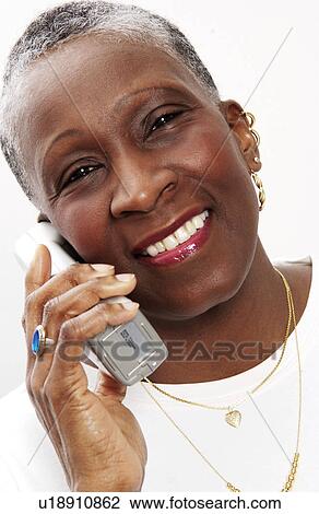 Stock Image - Older woman talking on cordless phone. Fotosearch