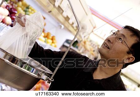 Stock Image - Oriental man at grocery store. Fotosearch