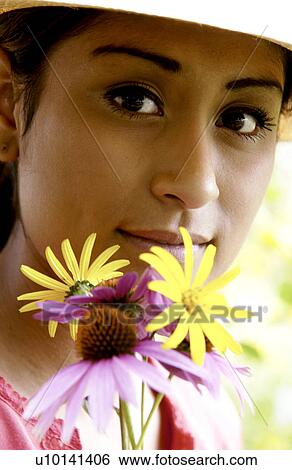 Stock Photograph - Woman holding flowers in garden. Fotosearch