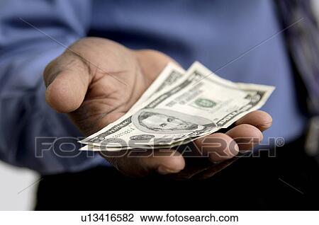 Stock Image - Businessman holding money. Fotosearch
