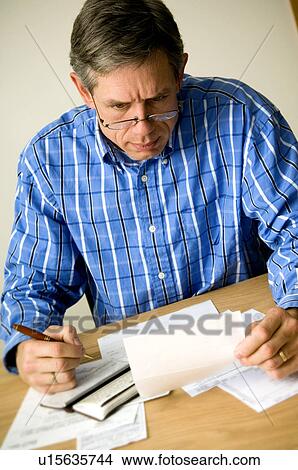 Picture - Man paying bills. Fotosearch