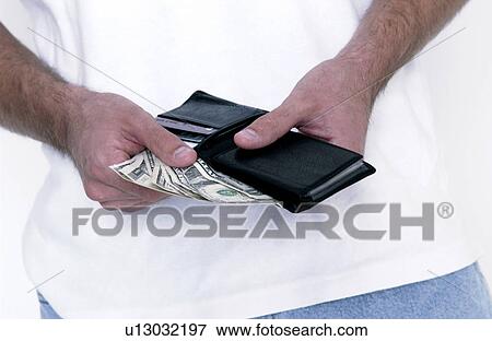 Stock Photo - Man putting money in his wallet . Fotosearch