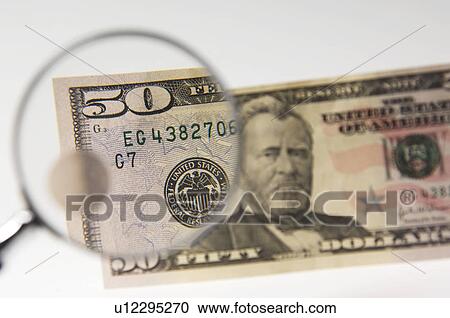Stock Image - Money under a magnifying glass. Fotosearch