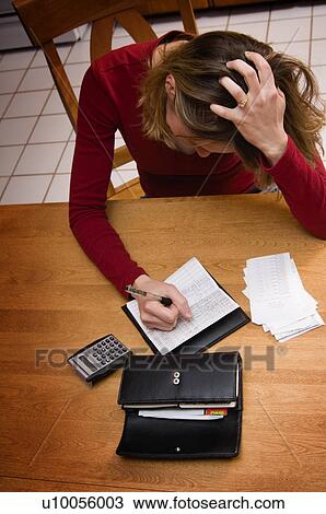 Stock Image - Woman balancing checkbook. Fotosearch