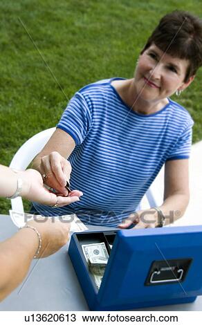 Woman collecting money at garage sale View Large Photo Image Stock Image - Woman collecting money at garage sale. Fotosearch