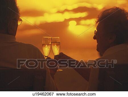 Senior couple toasting at sunset oceanside View Large Photo Image Stock Photo - Senior couple toasting at sunset oceanside. Fotosearch