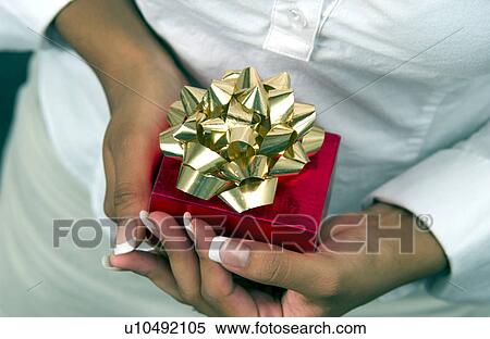 Stock Photography - Woman holding Christmas present. Fotosearch