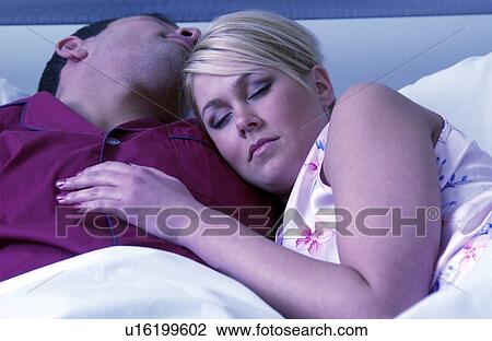 Stock Image - Couple sleeping in bed. Fotosearch