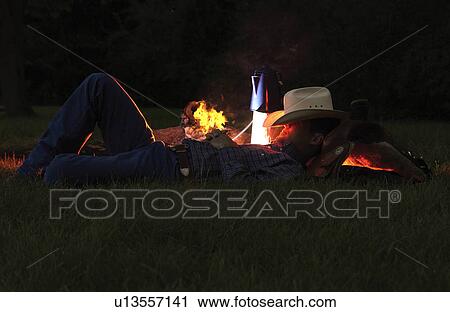 Stock Image - Cowboy near campfire. Fotosearch