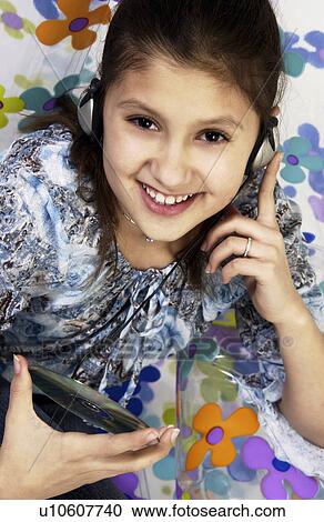 Stock Image - Girl listening to headphones. Fotosearch