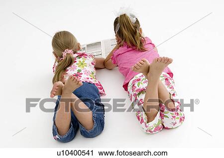 Stock Image - Girls reading newspaper. Fotosearch