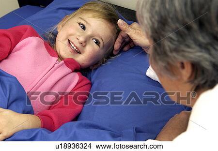 Picture - Grandma putting granddaughter to bed. Fotosearch