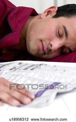Stock Image - Hispanic man fell asleep while reading newspaper. Fotosearch