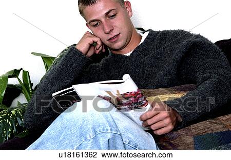 Stock Image - Man reading magazine. Fotosearch