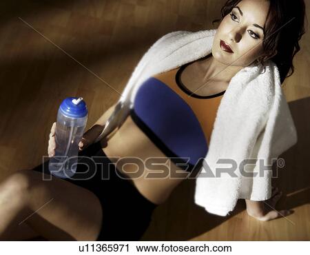 Stock Image - Woman relaxing with a drink of water. Fotosearch