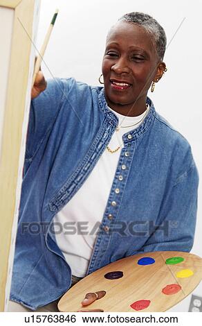 Stock Photograph - African American woman painting. Fotosearch