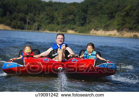 Stock Image - Dad with kids on inner tube. Fotosearch
