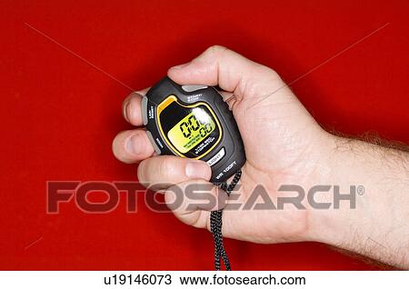 Stock Image - Man holding stopwatch. Fotosearch