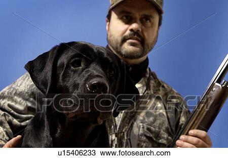 Stock Image - Man out hunting with his dog. Fotosearch