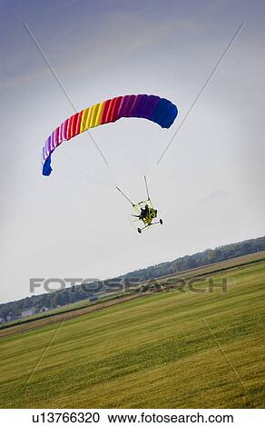 Stock Image - Person with powered paraglider. Fotosearch