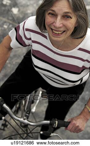 Stock Photograph - Senior woman bicycling. Fotosearch