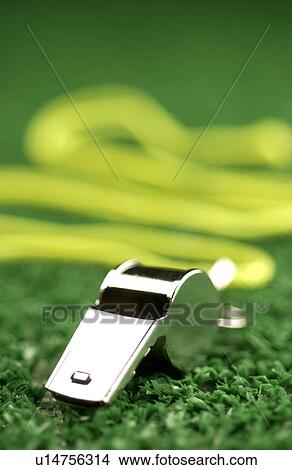 Picture - Whistle laying on green astroturf. Fotosearch