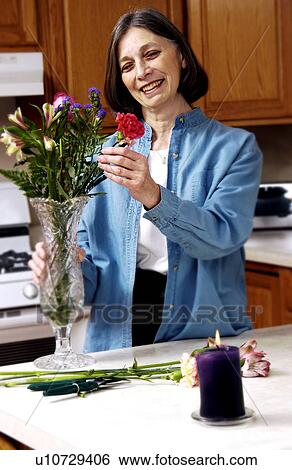 Woman arranging flowers View Large Photo Image Stock Photograph - Woman arranging flowers. Fotosearch
