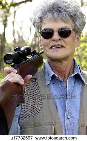 Stock Photo - Woman carrying rifle. Fotosearch