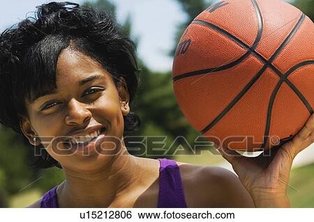 Stock Photograph - African American woman playing basketball. Fotosearch
