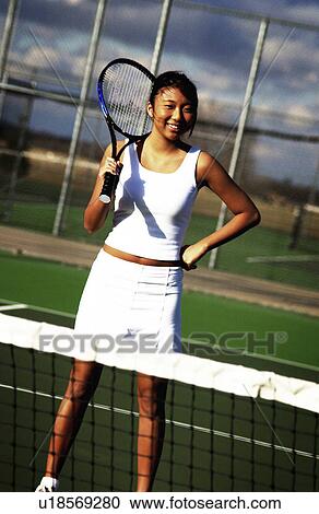 Stock Image - Asian woman playing tennis. Fotosearch