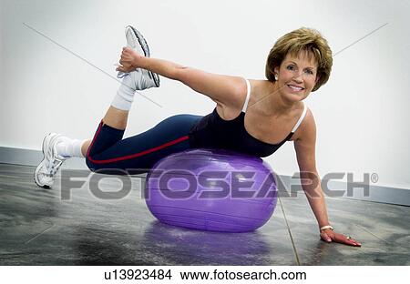 Picture - Woman using exercise ball. Fotosearch