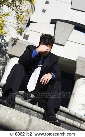 Stock Image - Businessman in front of office building. Fotosearch