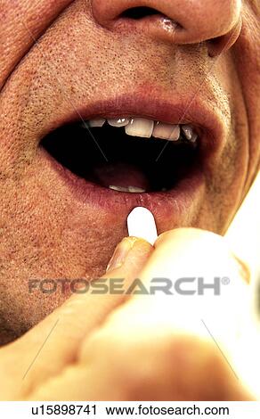 Stock Image - Man taking pills. Fotosearch