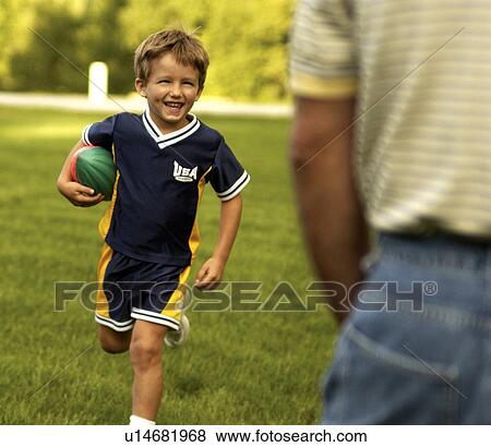 Stock Photo - Boy playing football. Fotosearch