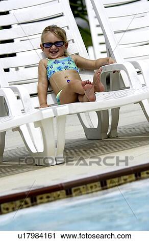 Little girl sitting in a chair by a pool View Large Photo Image Stock Image - Little girl sitting in a chair by a pool. Fotosearch