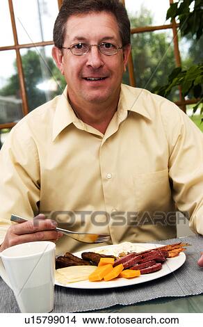 Man eating breakfast View Large Photo Image Picture - Man eating breakfast. Fotosearch
